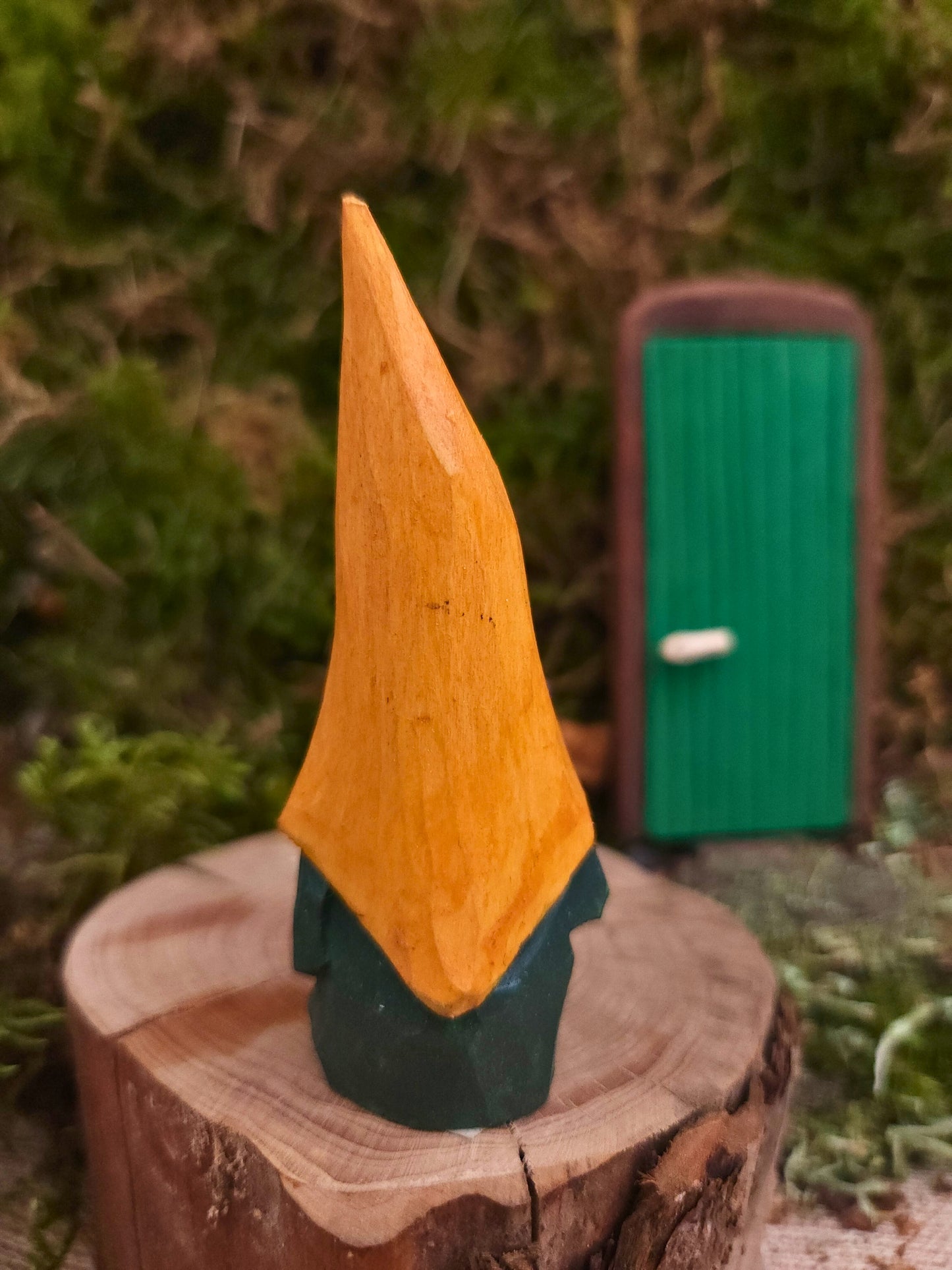 Nisse Nr. 71 med gul hatt och grön kropp, håller en träslev – unik träfigur för miniatyrvärld eller som gåva.