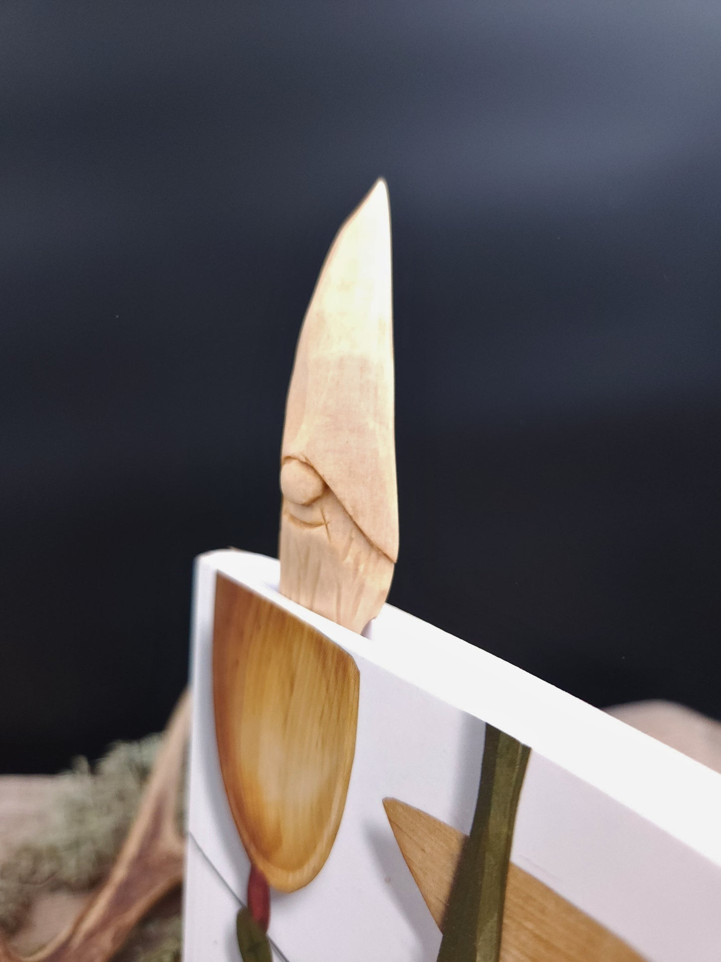 Collectible reading bookmark with Nisse (Gnome, Wichtel) head – hand-carved Scandinavian wooden folk art, unique artisan gift for book collectors.
