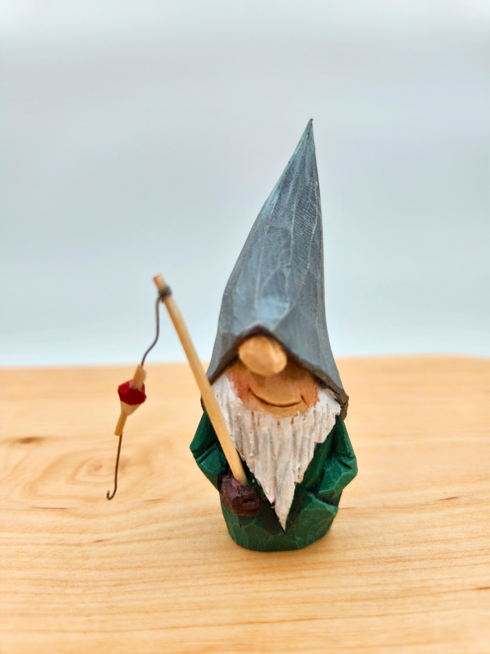 Scandinavian Nisse (Gnome, Wichtel) with grey hat holding fishing rod – handmade wood carving, unik svensk träfigur, perfekt collectible gift for folklore fans, Elfenszene och DIY miniatyrlandskap.
